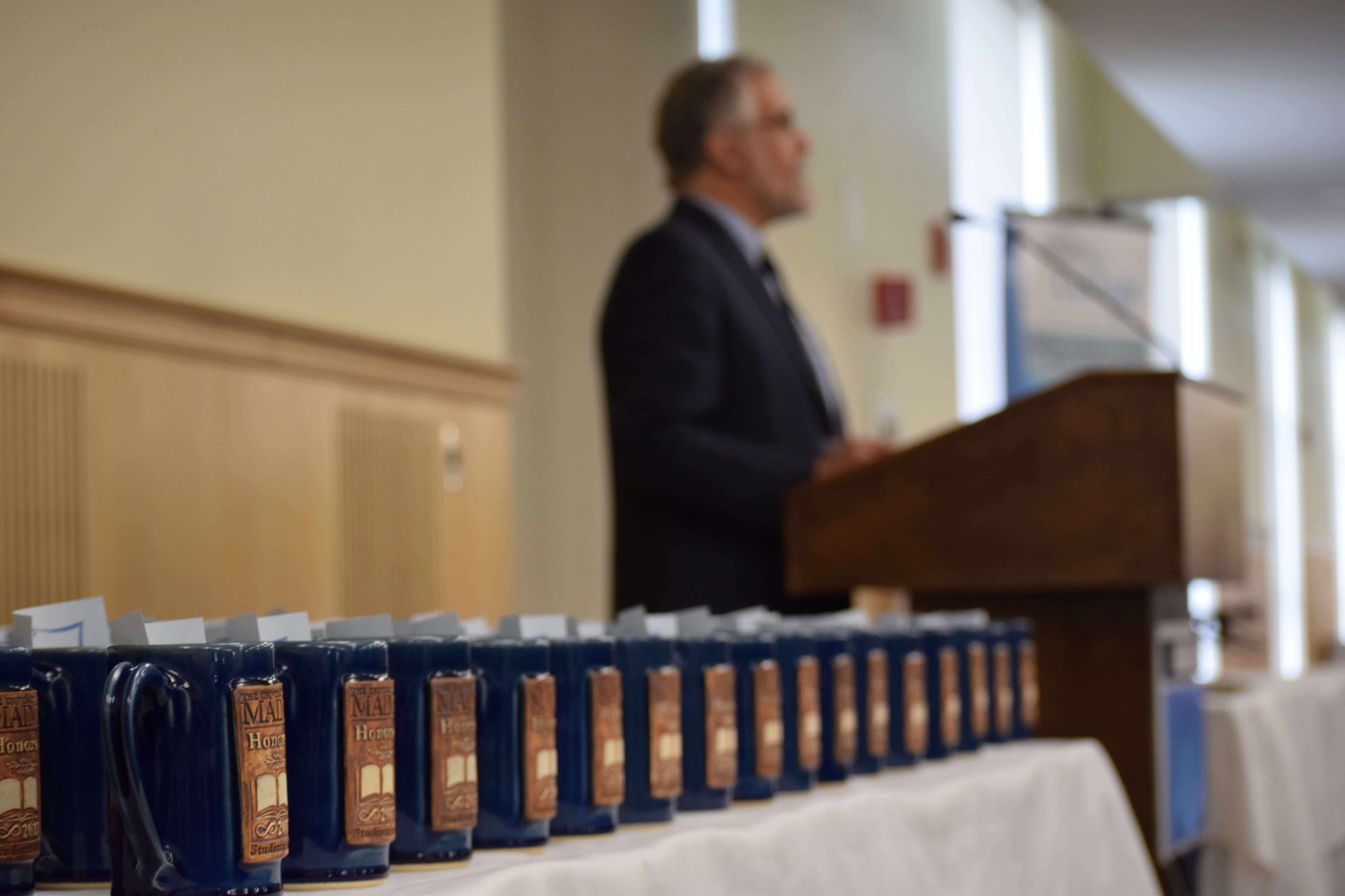 François Amar speaks at Celebration next to a table covered in Honors Steins.