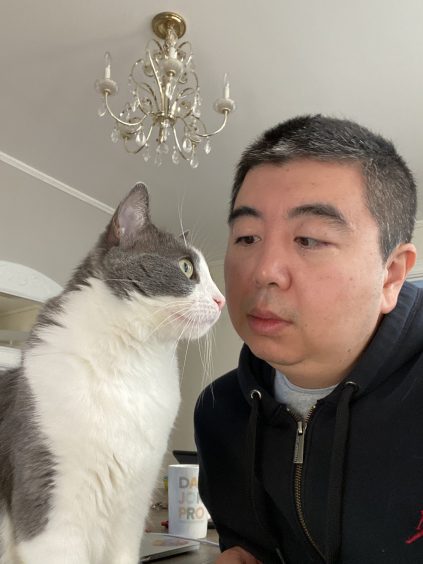 Hao Hong with a grey and white cat