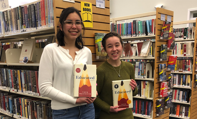 First-year Honors students Rebecca Collins and Elaine Thomas hold their copies of the book Educated in the Orono Public Library