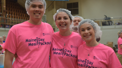 Lauren Ryan (center) volunteers at the 2019 Maine Day Meal Packout along with Alec Penn (left) and Emma Hutchinson (right).