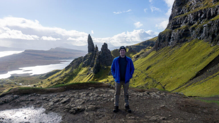 An Honors student poses in front of a scenic vista while traveling.