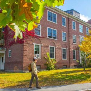 A student walking outside of Colvin Hall, one of the Honors dorms.