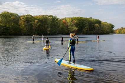 Honors students on stillwater river paddleboarding
