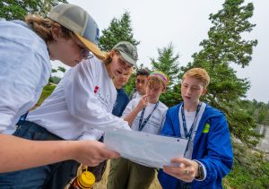 students looking at and pointing at a map