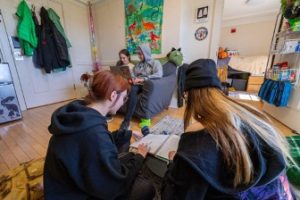 A group of students studying in an Honors dorm room setting 
