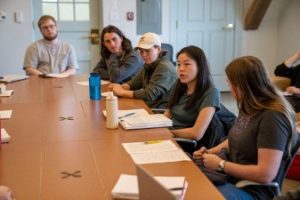 A group of students gathered around a table in discussion